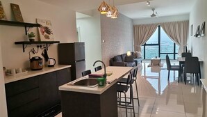 Een moderne keuken met een centraal eiland, een eetgedeelte met uitzicht en een zithoek met een bank en een tafel.