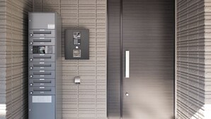 A modern elevator with a keypad and a control panel on the wall, next to a closed elevator door. - Everynet Shinjuku II by Tranova (Tokyo)