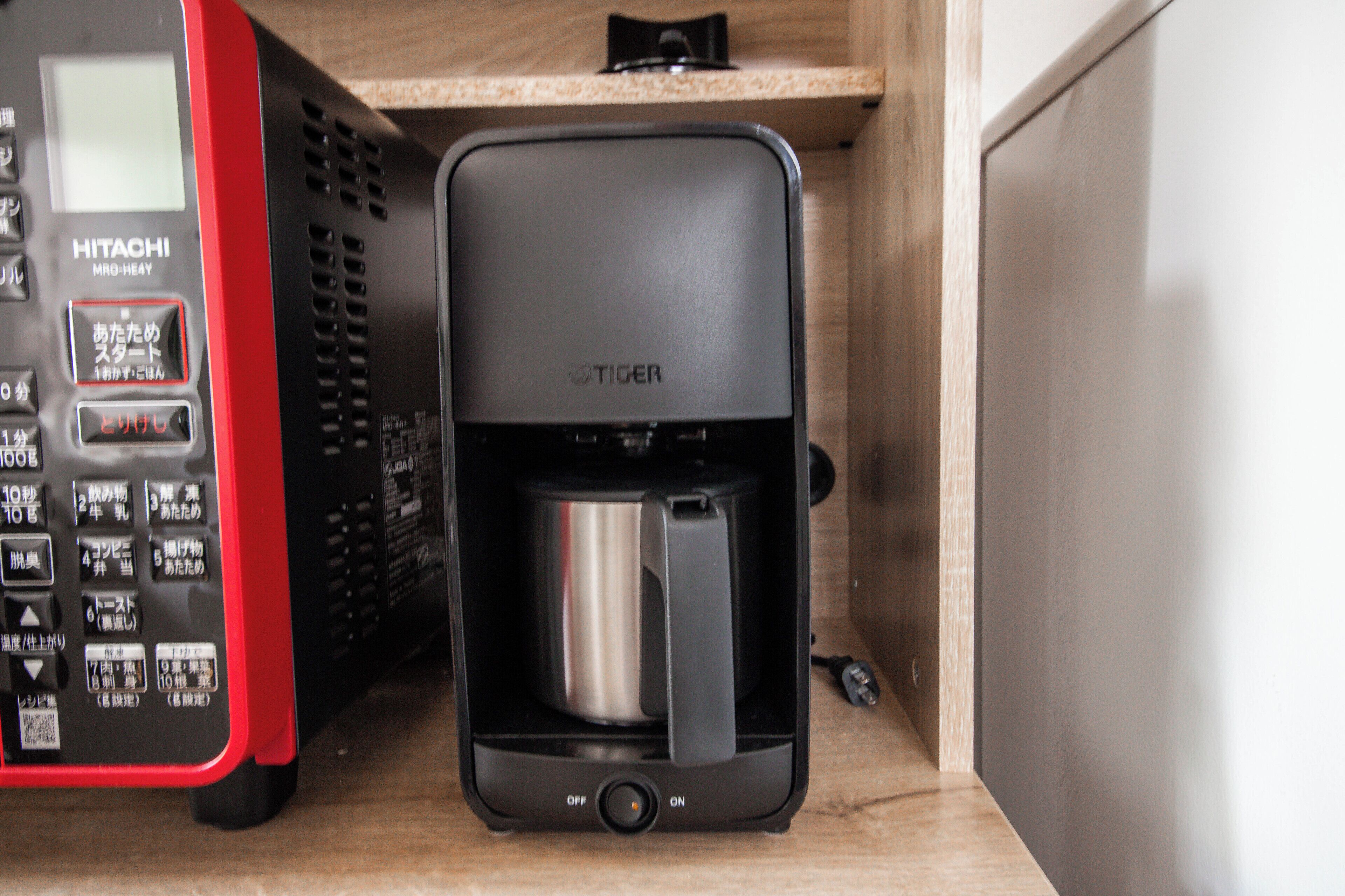 Une machine à café dotée d’un panneau de commande et d’une verseuse en acier inoxydable.