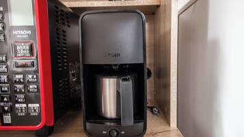 Une machine à café dotée d’un panneau de commande et d’une verseuse en acier inoxydable.