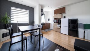 Una cocina moderna con comedor, que incluye una mesa, sillas, refrigerador, microondas y alacenas.