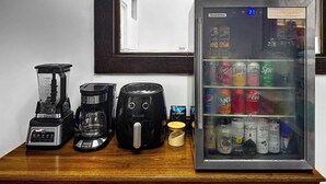 A kitchenette with a blender, coffee maker, and toaster, and a refrigerator stocked with beverages. - Hospedajes Alta Terra (Quetzaltenango)