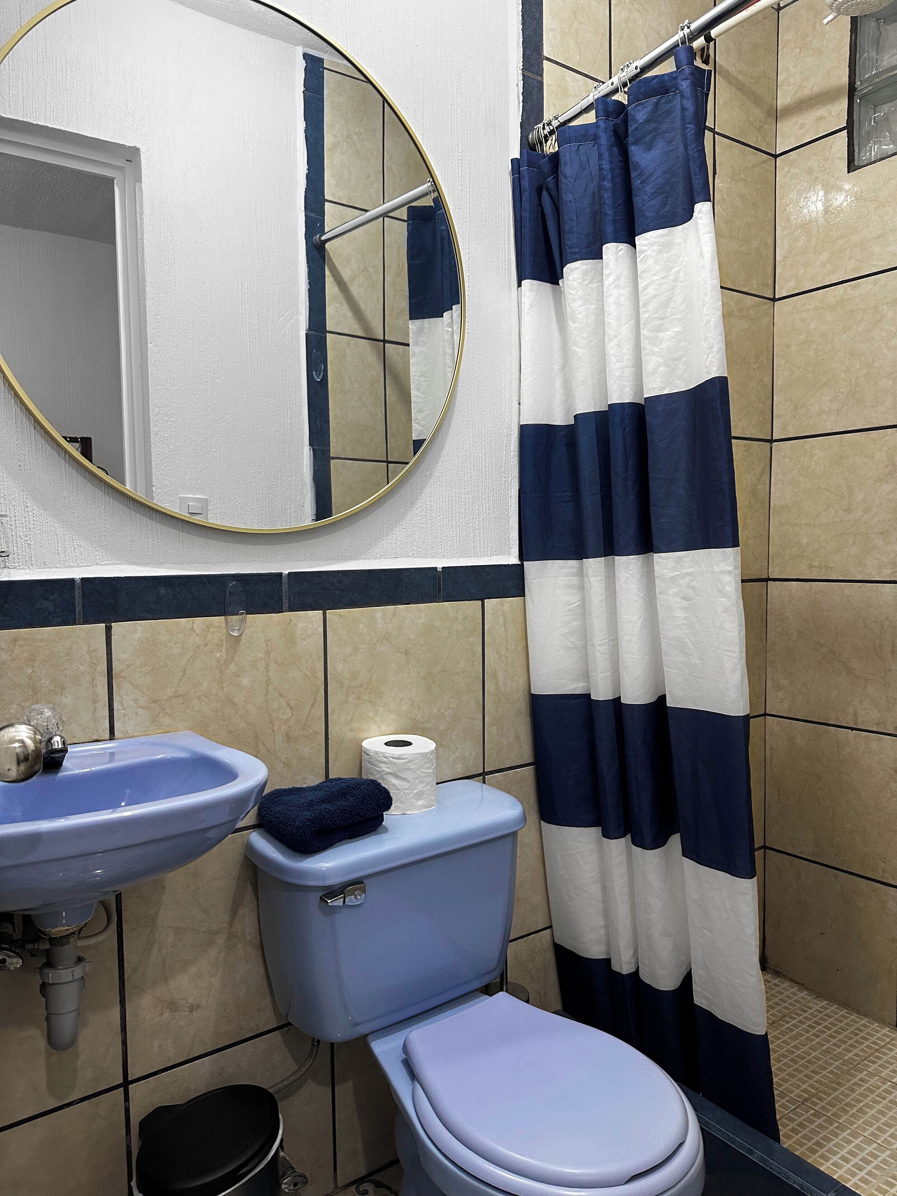 Ein Badezimmer mit Waschbecken, Toilette und Duschvorhang.