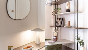 A modern living room with a round mirror, a white table lamp, and a wooden coffee table. There are shelves with decorative items and a green chair. - Lycabettus Modern Retreat (Athina)