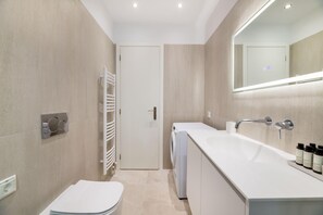 A modern bathroom with a toilet, a sink, and a mirror. - Essence 2BR Living in Marousi (Marousi)