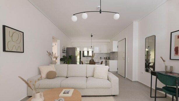 Un salon moderne comprenant un canapé, une table basse et un coin repas avec une chaise.