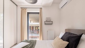 Une chambre d’hôtel moderne avec un grand lit, une vue sur un espace extérieur et une fenêtre avec des rideaux.