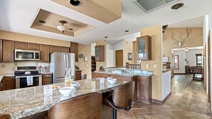 A spacious kitchen with granite countertops, wooden cabinets, and stainless steel appliances. - Xbox*Ping Pong* Pop-a-shot*Game Room* (Flagstaff)