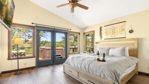 A bedroom with a bed, a ceiling fan, and a view of the outdoors. - Xbox*Ping Pong* Pop-a-shot*Game Room* (Flagstaff)