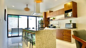 Una cocina moderna con una isla central, armarios de madera y microondas integrado.