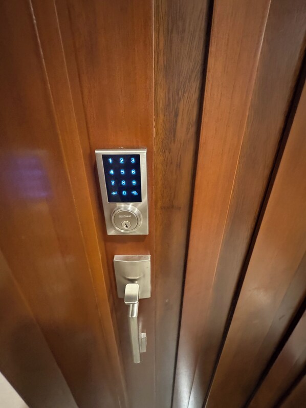 A wooden door with a digital keypad lock.