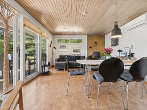 A modern interior with a dining area, a sofa, and a table.