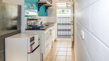 A compact kitchen with a microwave, sink, and a small countertop.
