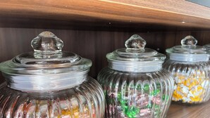 A shelf with glass jars containing colorful candies. - Studio11 (Torgau)