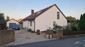 Ein Wohnhaus mit Satteldach, Garage und befestigter Auffahrt.
