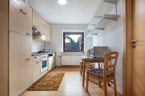 Une cuisine compacte avec des meubles en bois, un four encastré et une fenêtre offrant une belle vue.