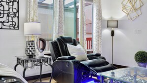 A modern living room with a massage chair, a glass coffee table, and a floor lamp. - Sunrise Villa: Solar panels, updated (Bothell)