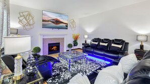 A modern living room with a black leather sofa, a glass coffee table, and a fireplace. - Sunrise Villa: Solar panels, updated (Bothell)