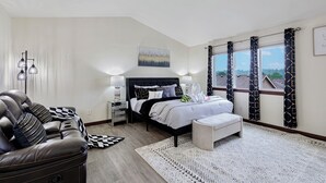 A bedroom with a bed, a sofa, a nightstand, and a window with curtains. - Sunrise Villa: Solar panels, updated (Bothell)
