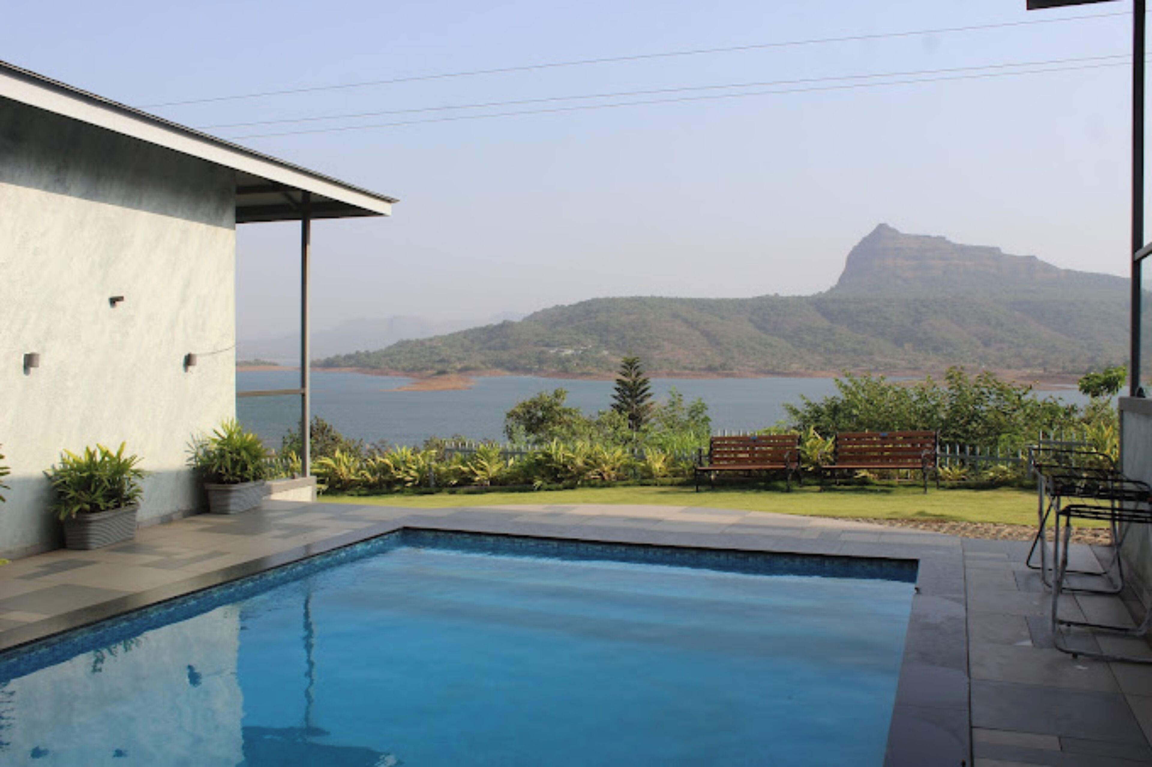 A swimming pool with a view of a lake and mountains.