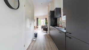 Una cucina moderna con mobili scuri, una cappa aspirante nera e uno schienale piastrellato.