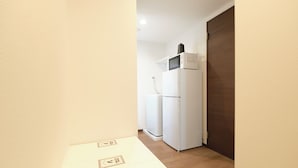 Eine kleine Küche mit Kühlschrank, Mikrowelle und einer Arbeitsplatte.