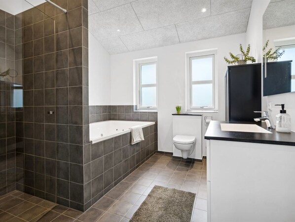 Une salle de bain moderne avec une baignoire, des toilettes et un lavabo.