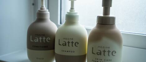Tre flasker 'mā & mē Latte' hudplejeprodukter står på et vindueskar.