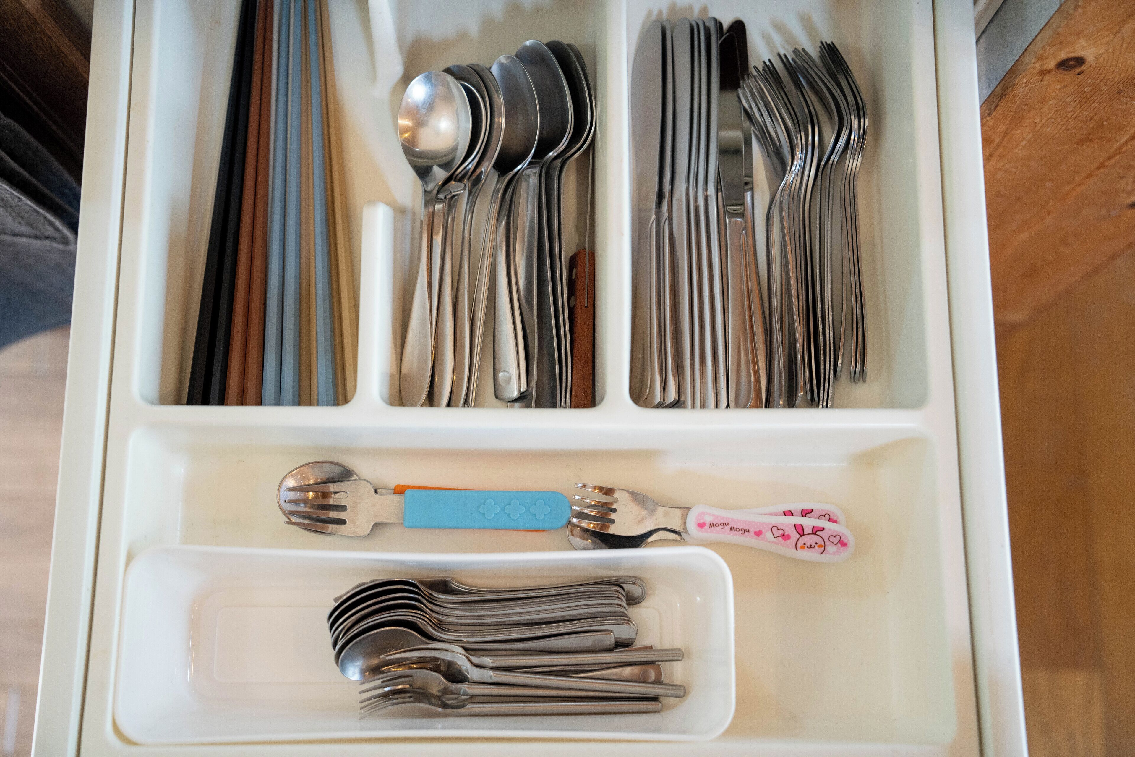 A drawer with various utensils organized in compartments.