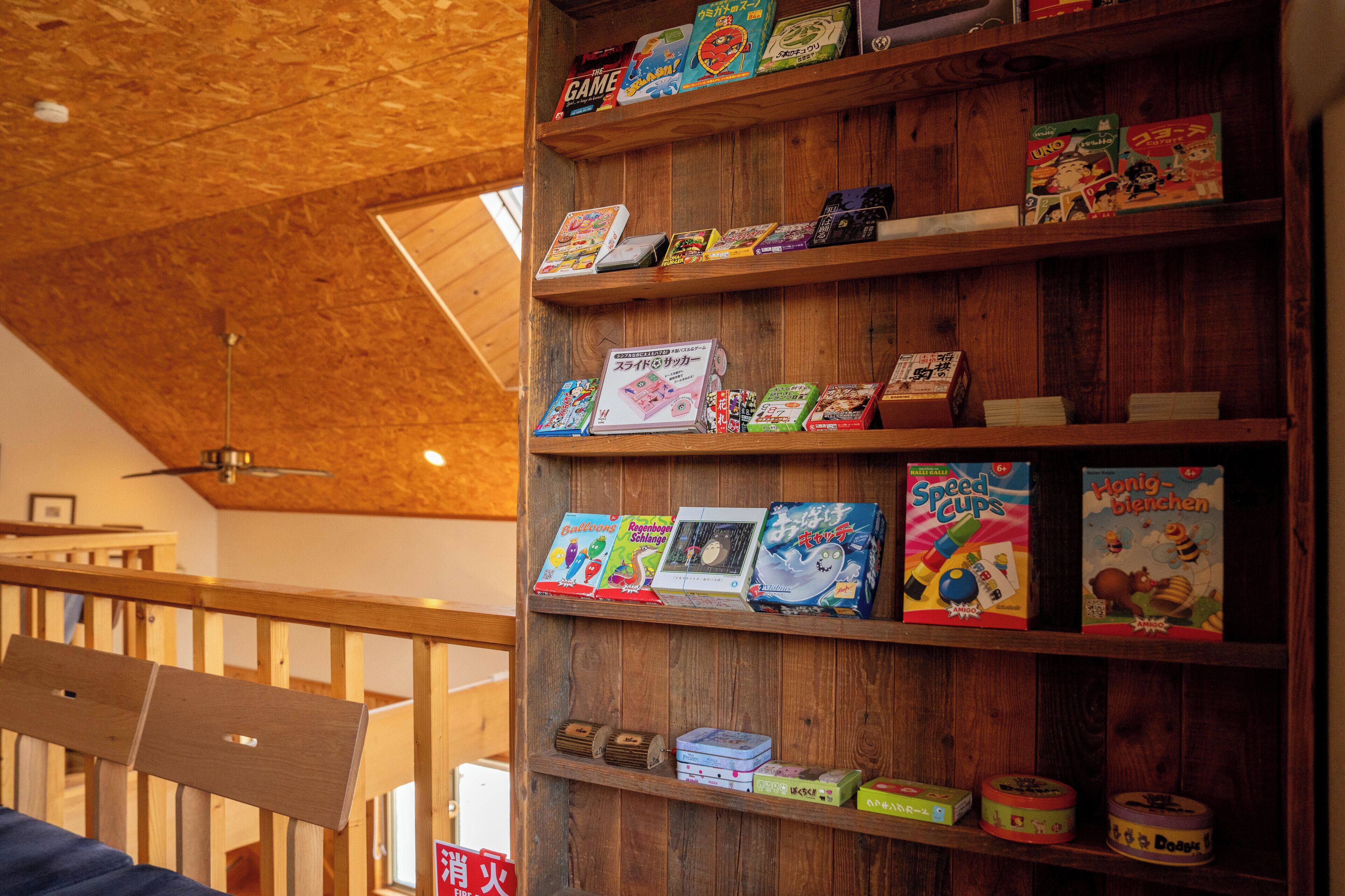A wooden bookshelf with various board games and puzzles.