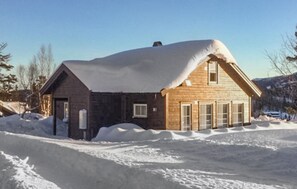 A wooden cabin with a snow-covered roof, surrounded by snow. - 4 bedroom cozy home in Skollenborg (Skollenborg)