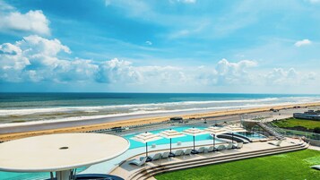A resort with a pool area, beach access, and a view of the ocean.
