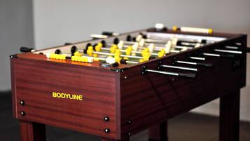 A wooden foosball table with the brand name "BODYLINE" on the side.