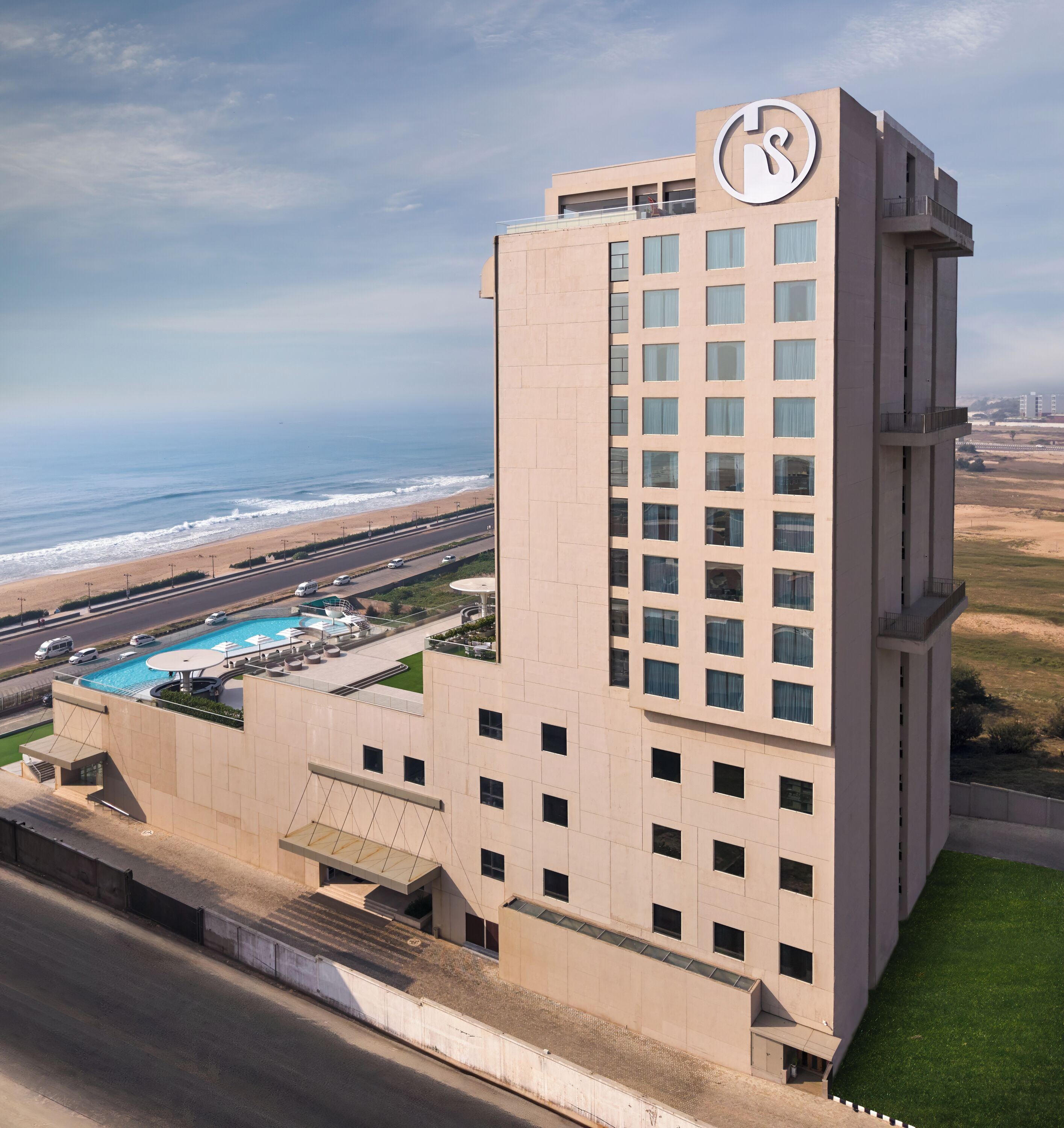 A high-rise hotel with a pool and ocean view.