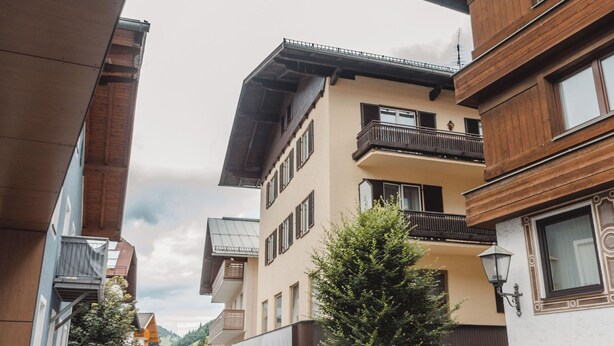 A multi-story building with balconies and a wooden facade.