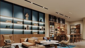 A modern living room with a sofa, armchairs, a coffee table, and a bookshelf. - Fairfield by Marriott Chuzhou Railway Station (Chuzhou)