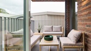 A balcony with a wooden table, two cushioned chairs, and a green bowl. - The Tottenham Hale Crib - Trendy 2bdr Flat With Balcony (London)