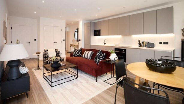 A modern living room with a red sofa, black coffee table, and a dining area with a round table. - The Tottenham Hale Crib - Trendy 2bdr Flat With Balcony (London)