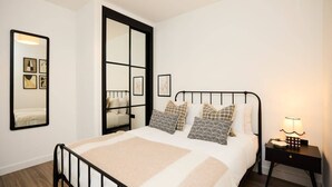 A bedroom with a bed, bedside table, and a mirror. - The Tottenham Hale Crib - Trendy 2bdr Flat With Balcony (London)