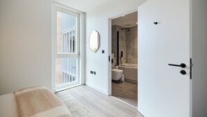 A modern bathroom with a shower, toilet, and a large mirror. - The Tottenham Escape - Lovely 2bdr Flat With Balcony (London)