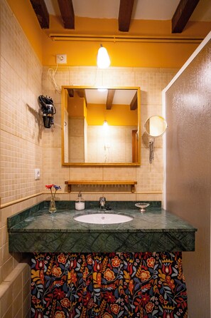 A bathroom with a sink, mirror, and a decorative tile backsplash.
