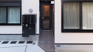 A modern building with a flat facade, large windows, and a door with a small step leading to the entrance. - Sky Up Oshiage by Tranova (Tokyo)