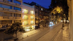 Um edifício com várias andares, varandas e uma loja no andar térreo.