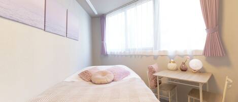 Un dormitorio con cama, escritorio y sillas.