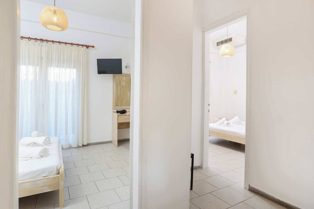 Une chambre d’hôtel équipée d’un lit, d’un bureau, d’une télévision et d’un espace douche.