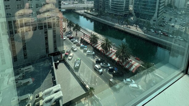 A high-rise building with a view of a river and other buildings.