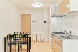 Une cuisine moderne avec un coin repas, des armoires en bois et un évier en acier inoxydable.