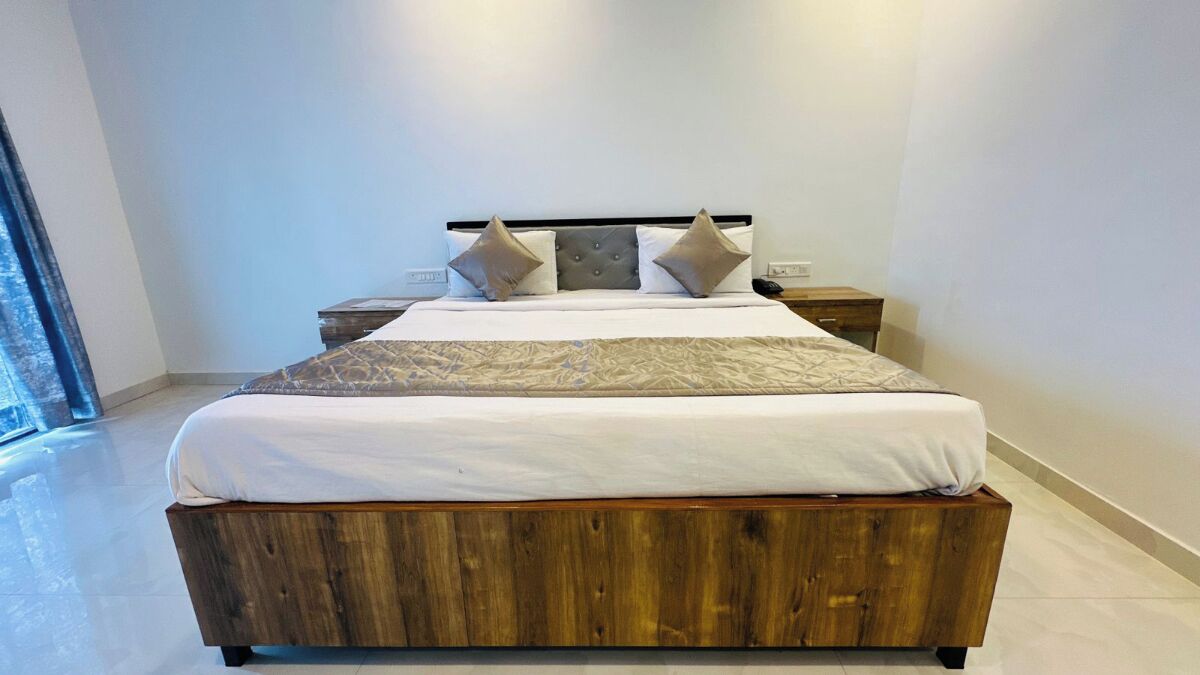 A modern bedroom with a wooden bed, a nightstand, and a bedside table.