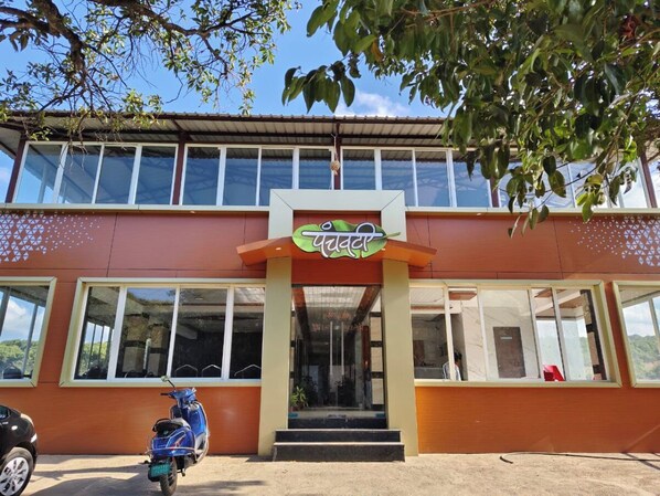 A building with a sign reading "Panda" and a scooter parked in front.