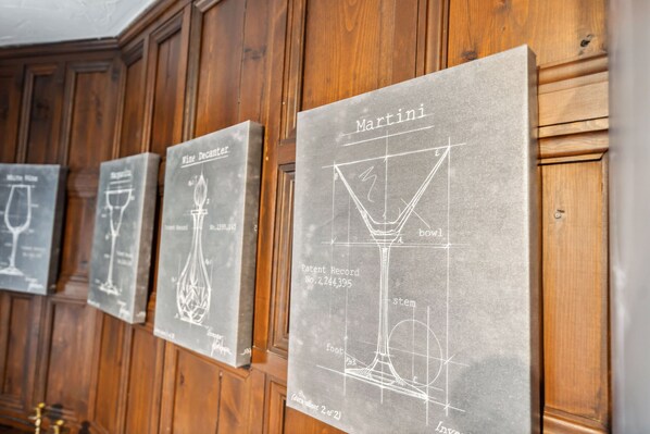 A series of chalkboard-style signs with wine glass designs and text, mounted on a wooden wall.